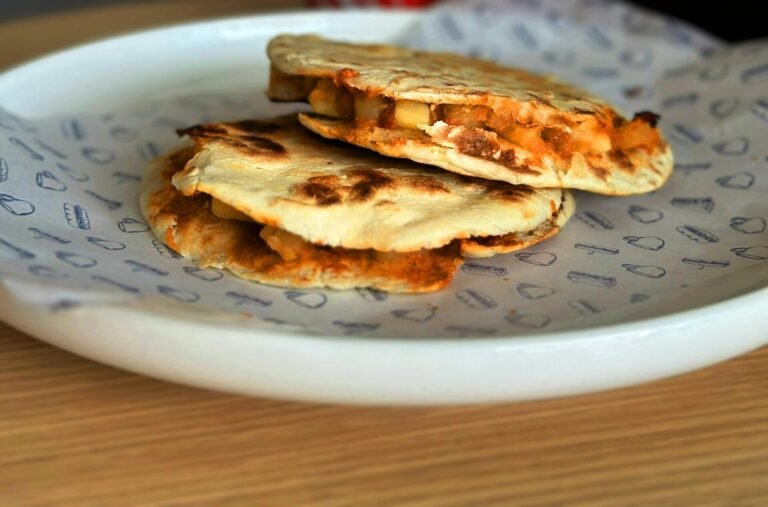 Stuffed kulchas stacked on a printed plate
